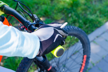 A cyclist rides a bicycle and holds a cigarette