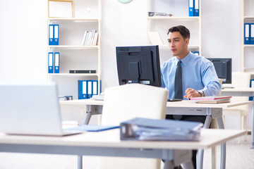 Handsome businessman employee sitting at his desk in office