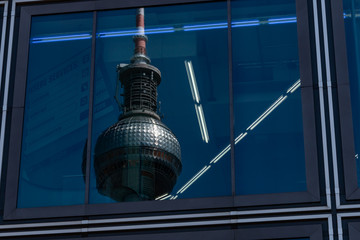 Berlin Alexanderplatz TV tower reflects in a glass facade