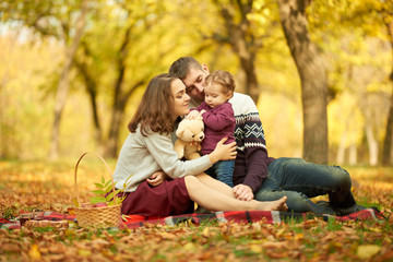 Fototapeta premium A cheerful family in an autumn park at a picnic. Concept of rest and walk