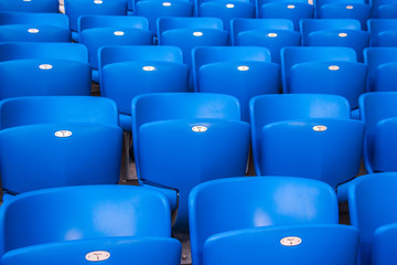 Rows empty bright blue plastic seats in a stadium