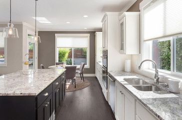 Beautiful Kitchen in New Luxury Home with Island, Oven, Range, Stainless Steel Appliances, and...