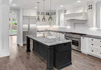 Beautiful Kitchen in New Luxury Home with Island, Oven, Range, Stainless Steel Appliances, and Refrigerator