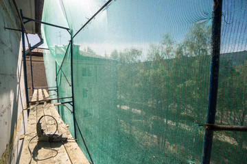 Hand drill on the scaffolding on altitude. Concept repairing the wall panel