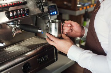 Barista making coffee. Preparing milk for cappuccino
