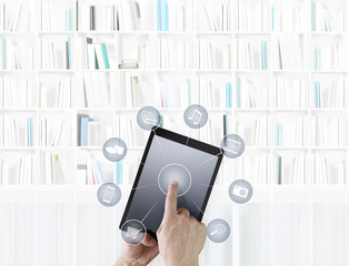 hand touching digital tablet with icons isolated on library background