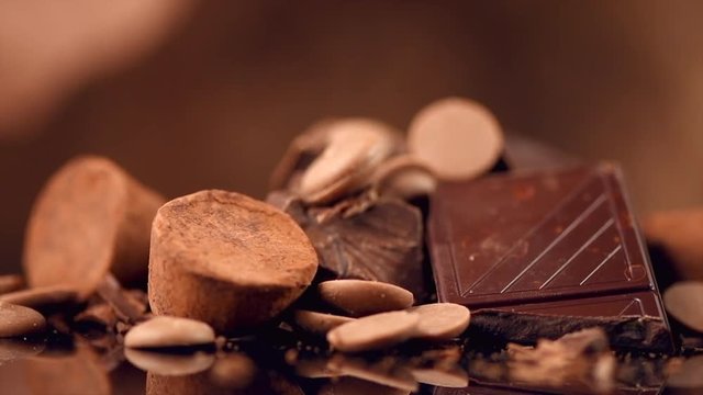 Chocolate. Assorted chocolate sweets and candies rotated over dark background. Confectionery. 4K UHD video 3840X2160