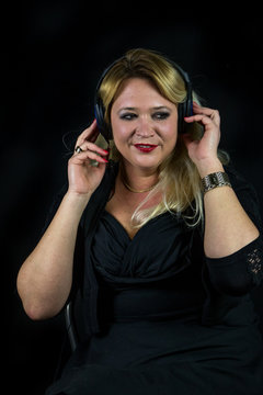 Blonde Frau hört konzentriert Musik über Kopfhörer