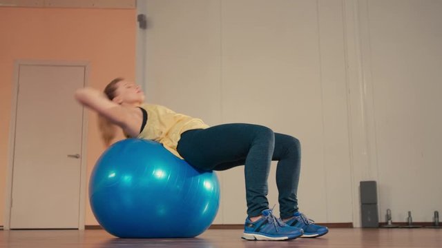Sporty Fit Lady is Doing Situps Exercises and Abs Workout on a Fitball while Training in the Gym
