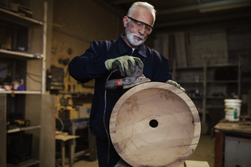 Fototapeta na wymiar Senior master carpenter working in his woodwork or workshop.