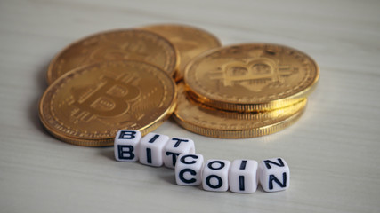 BITCOIN cube written in alphabet and pile of bitcoin.