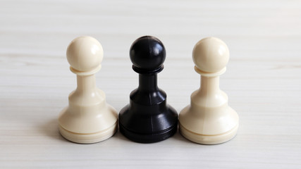 Two white chessman and a black chessman.