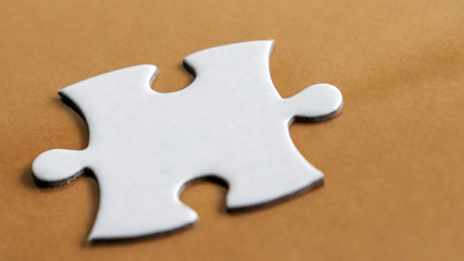 Fototapeta premium A&nbsp;piece&nbsp;of&nbsp;a&nbsp;puzzle&nbsp;on&nbsp;the&nbsp;light brown&nbsp;background.