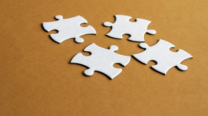 Four pieces of puzzle on the brown background.