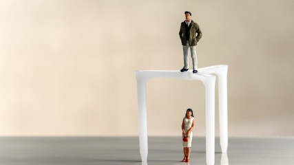 A miniature man and woman standing on different heights.