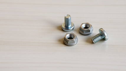 Two bolt and two nut on the wood background. Because bolts and nuts are different shapes,...
