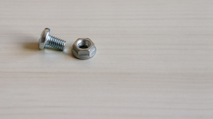 Bolt and nut on the wood background. 