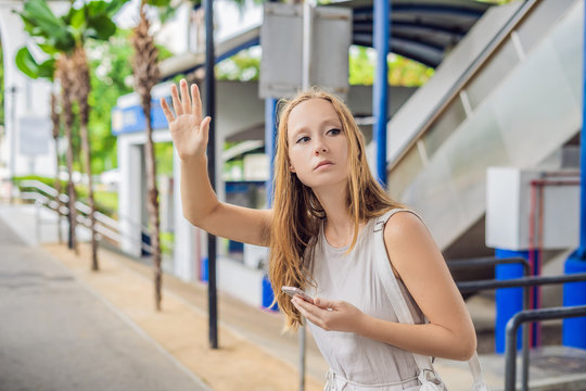 Woman Using Phone App For Taxi Ride Hailing Service Or Using Phone App To Find Directions And Guide During Travel. Girl Tourist On Street