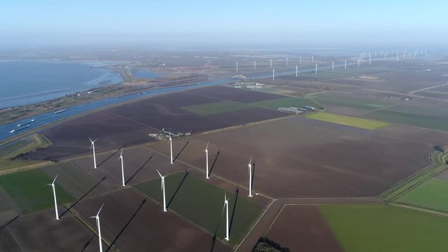 Aerial bird view footage of wind farm a group of wind turbines in the same location used to produce electricity pruducing sustainable renewable energy provided by national recources 4k quality