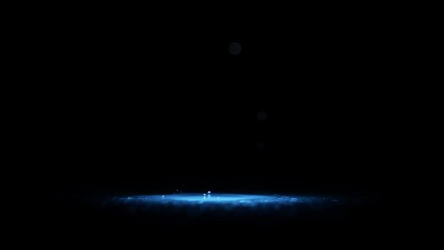 Water drops in cold blue light on black background. Blue liquid droplets splash