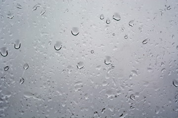 Water rain drop on wet weeping grey surface of window glass. Texture. Background