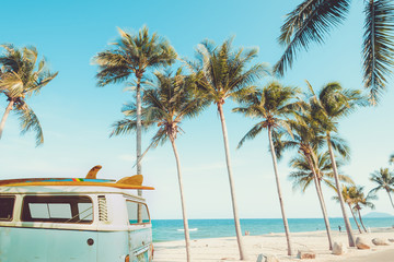 Oldtimer geparkt am tropischen Strand (Meer) mit Surfbrett auf dem Dach - Freizeitausflug im Sommer. Retro-Farbeffekt