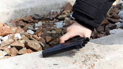 The hand of a woman holding a gun.