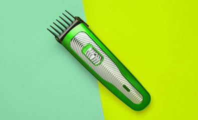 A hair clipper on a colored pastel background. Minimalist trend. Top view.