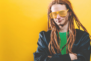 Funky fashion man with dreadlocks on a solid colored background