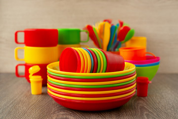 Set of dishes made of plastic. Colorful multi-colored plastic dishes for eating on a picnic. Crockery, easy to use in tourism and travel.