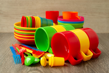 Colorful plastic ware. A set of dishes made of multi-colored plastic for outdoor recreation. Plastic plates, mugs, picnic cups, camping and tourism.