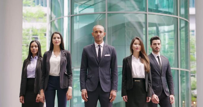 Portrait of business people of different ethnic backgrounds dressed in suits, they smile and cross their arms. Concept of: internationality and career, cooperation and team.