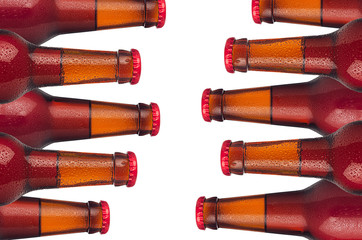 Decorative border of sealed cold red ale beer bottles with water drops isolated on white...