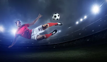 Gordijnen Voetballer in actie op stadionachtergrond. © efks