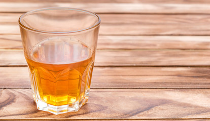 Glass of whisky on wooden background. Space for text.