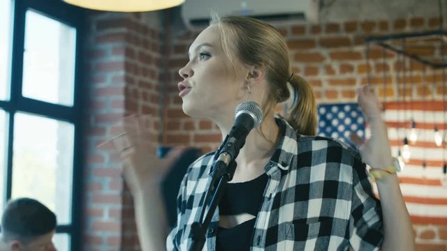 Young singer in band looking dissatisfied with musicians bad playing and provoking conflict in group on rehearsal