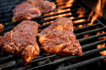 grilled pork with flames on barbecue