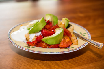 plate with fried vegetables and row avocado