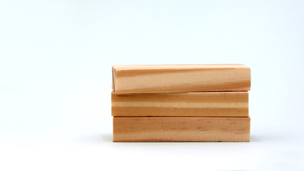 A pile of three wooden blocks on a bright background.
