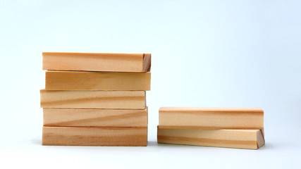 A pile of five wooden blocks beside a pile of two wooden blocks.