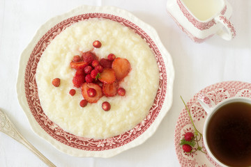 A useful breakfast of rice porridge with strawberry sauce served with tea.
