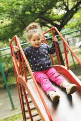 curly girl playing on playground