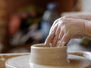 pottery handcraft hobby. hands forming and shaping clay on potter wheel