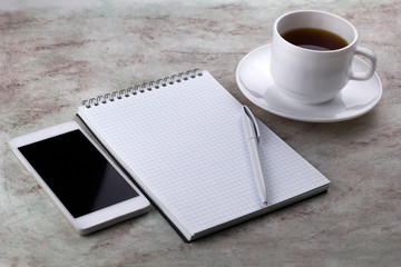 coffe cup ,cel phone and notebook on a marble background