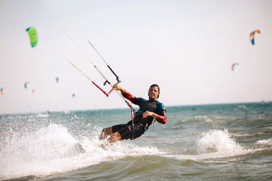 Kitesurfing Kiteboarding action photos man among waves quickly goes