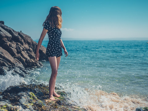 Woman standing on rocks by the waves