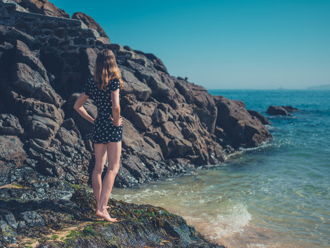 Woman standing on rocks by the waves