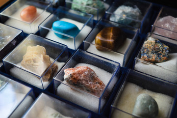 collection of minerals and precious stones in glass boxes