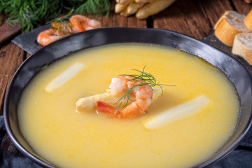 delicious asparagus cream soup with prawns and fresh dill