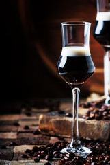 Two-layer cocktail with coffee liqueur, vintage wood background, selective focus